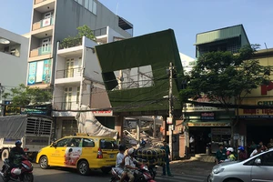 Biển quảng cáo đổ đè trụ điện ở công trình đang tháo dỡ