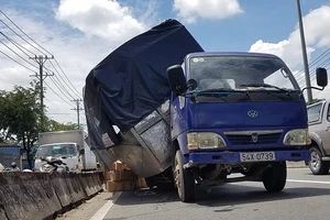 Xe tải đang chạy thì rớt bánh, lật nghiêng trên quốc lộ
