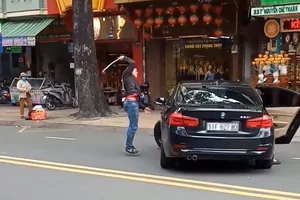Thanh niên múa gậy đập xe BMW trên đường ở TP.HCM 