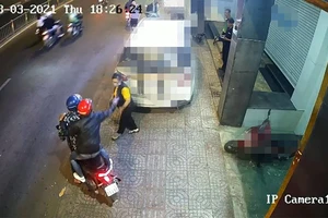 Hai thanh niên bỏ chạy sau khi tạt ca mắm tôm vào người chị T ngay trước trụ sở công ty. Ảnh chụp từ clip