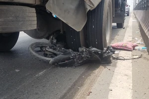 Chạy xe máy lên cầu vượt có biển cấm, 2 người bị xe tải cuốn vào gầm