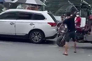 Người đàn ông cầm mã tấu chém xe ba gác trên đường