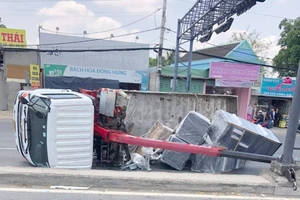 Xe tải cẩu kéo gãy trụ điện, lật ngang trên Quốc lộ