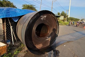 2 cuộn sắt trên xe đầu kéo bị đứt xích giằng, rơi xuống Quốc lộ 1