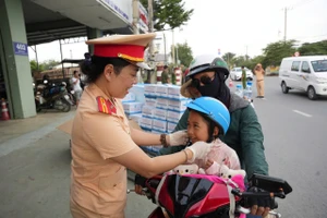 Hàng trăm người dân về quê nghỉ lễ được tặng nón bảo hiểm, nước suối ở Bình Chánh