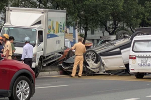 Xe tải lao dải phân cách tông ô tô lật ngửa trên đại lộ Võ Văn Kiệt