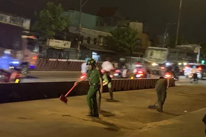 Công an phường Đông Hưng Thuận dọn cát trên đường đảm bảo an toàn cho người dân