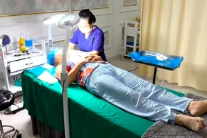 Nữ lao công đang thực hiện căng da mặt cho khách tại cơ sở Viện thẩm mỹ Kangzin Đà Nẵng. Ảnh: MT.