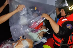 Một cháu bé được lực lượng cứu hộ đưa đến vùng an toàn. Ảnh: CA.