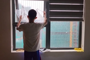 Người dân trên tầng cao NOXH dùng bao ni lông để chắn nước mưa thấm vào nhà. Ảnh: MINH TRƯỜNG.