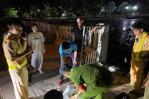 Hai em học sinh được cán bộ CSGT cứu đưa lên bờ an toàn. Ảnh: CA.