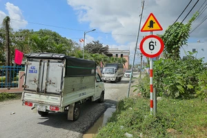 Đủ loại ô tô lớn nhỏ nối đuôi nhau đi vào đường dân sinh để lách trạm thu phí.