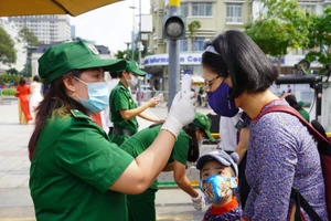 Người dân và du khách tham quan đường hoa Nguyễn Huệ (TP.HCM) được đo thân nhiệt kĩ càng. Ảnh: NGUYỄN TRÀ