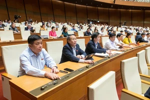 Các đại biểu biểu quyết thông qua các dự án một luật sửa nhiều luật.