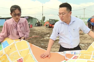 Ông Hoàng Văn Quân cùng đồng nghiệp trao đổi về dự án đường vành đai 3. Ảnh: NVCC