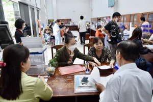 Cán bộ Trung tâm phục vụ hành chính công phường Xóm Chiếu, TP.HCM hỗ trợ người dân làm thủ tục.