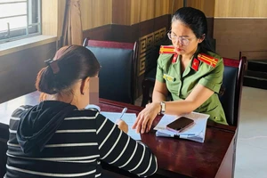 Công an làm việc với một trong những người bán tài khoản ngân hàng. Ảnh: CA
