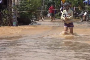 Biên Hòa ngập lụt, người dân giăng dây để đi về nhà