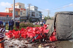 Xe tải lật, hàng trăm két bia vùi 2 người đi đường 