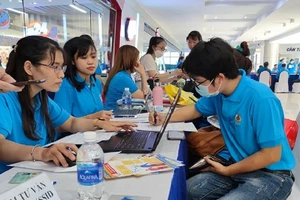 người lao động được nhân viên cơ quan bảo hiểm xã hội hướng dẫn cài VssID. Ảnh: Nguyễn Hiền