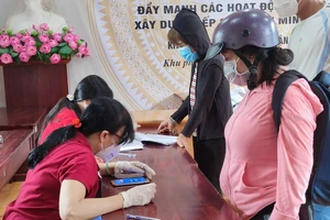 Người dân ở phường 5, quận Gò Vấp nhận hỗ trợ đợt 3. Ảnh: NGUYỄN HIỀN