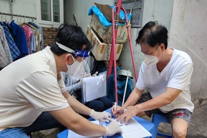 người dân phường 11, quận Phú Nhuận nhận hỗ trợ đợt 3. Ảnh: NGUYỄN HIỀN