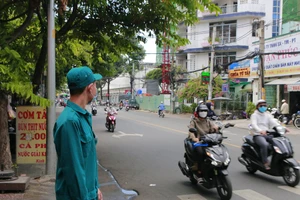 Một dân quân tự vệ đang làm nhiệm vụ điều tiết giao thông. Ảnh: Minh Thuận