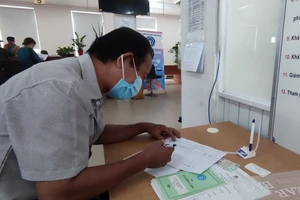 Người lao động đến cơ quan BHXH TP.HCM thực hiện các thủ tục liên quan đến BHXH. Ảnh: NGUYỄN HIỀN