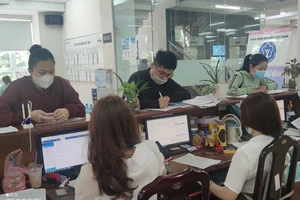 Người lao động đến cơ quan BHXH TP.HCM làm thủ tục liên quan đến BHXH. Ảnh: NGUYỄN HIỀN