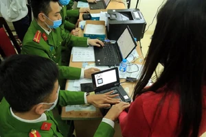 Lực lượng công an làm thủ tục cấp CCCD gắn chip cho người dân. Ảnh: UYÊN TRANG