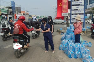 Nhóm từ thiện phát nước miễn phí cho người dân đang lưu thông trên đường. Ảnh: NGUYỄN HIỀN