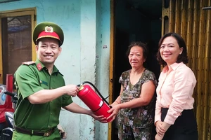 Công an phường tặng bình PCCC cho hộ dân trên địa bàn phường Bến Thành, quận 1. Ảnh: NGUYỄN HIỀN