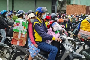 Chạy xe máy chở từ ba người về quê ăn tết có thể bị phạt. Ảnh: VŨ HỘI