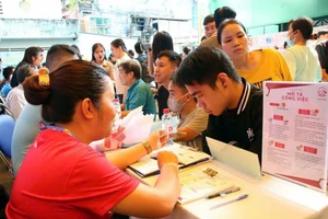 Ứng viên đang tìm hiểu về các vị trí tuyển dụng tại sàn giao dịch việc làm cho người khuyết tật. Ảnh: VÕ THƠ