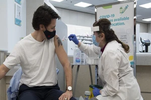 Nhân viên y tế đang tiêm vaccine ngừa COVID-19 cho một người đàn ông.