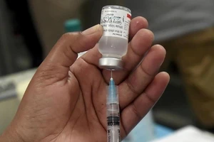 Nhân viên y tế lấy vaccine ra từ lọ.