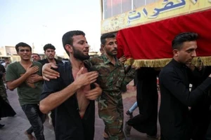 Những người đưa tang khiêng quan tài của một cảnh sát, người đã thiệt mạng trong vụ tấn công ở TP Kirkuk hôm 5-9.