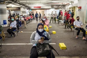 Người dân Indonesia ngồi chờ để được xét nghiệm COVID-19.
