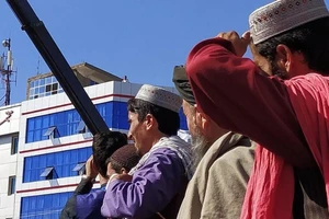 Người dân tập trung lại để chứng kiến cảnh Taliban treo xác bốn kẻ bị cáo buộc bắt cóc người khác.