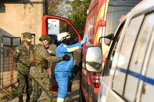 Các binh sĩ kiểm tra một tài xế xe cứu thương tại nhà tù Penitenciaria del Litoral sau khi vụ hỗn chiến xảy ra ở TP Guayaquil, Ecuador, ngày 28-9.