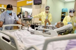 Các nhân viên y tế đang di chuyển những bệnh nhân lớn tuổi nhiễm COVID-19 đến phòng chăm sóc đặc biệt tại khoa cấp cứu tại bệnh viện Tan Tock Seng, Singapore.