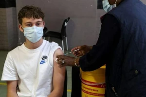 Nhân viên y tế đang tiêm vaccine ngừa COVID-19 cho một thiếu niên ở Johannesburg, Nam Phi, ngày 9-12.
