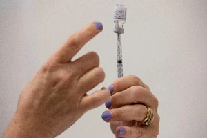 Một y tá bơm đầy vaccine vào ống tiêm cho bệnh nhân trong một phòng khám ở bang Michigan, Mỹ, ngày 29-9-2021.