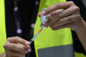 Một nhân viên y tế chuẩn bị một liều vaccine ngừa COVID-19 tại một trung tâm tiêm chủng ở Singapore vào ngày 21-4-2021.