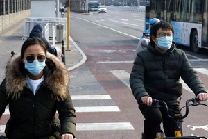 Người dân Trung Quốc đeo khẩu trang đi xe đạp ở Bắc Kinh, ngày 30-1. 