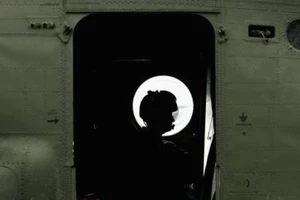 Một phi công ngồi trên máy bay trực thăng Chinook của lực lượng Không quân Hoàng gia Anh.