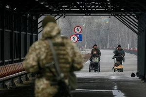 Người dân đi qua ranh giới giữa khu vực ly khai và đất thuộc chủ quyền Ukraine tại khu định cư Stanytsia Luhanska, ngày 23-2.