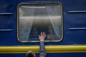 Những đứa trẻ chào tạm biệt cha mình trên chuyến tàu sơ tán từ Kiev đến Lviv, Ukraine, vào ngày 3-3.