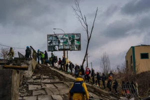 Người dân Ukraine băng qua sông Irpin gần thủ đô Kiev, ngày 4-3.