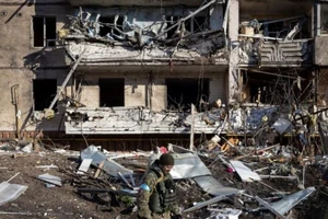 Một binh sĩ Ukraine kiểm tra đống đổ nát của một chung cư bị phá hủy ở Kiev vào ngày 15-3 sau khi Nga tấn công vào khu dân cư khiến ít nhất 2 người thiệt mạng.